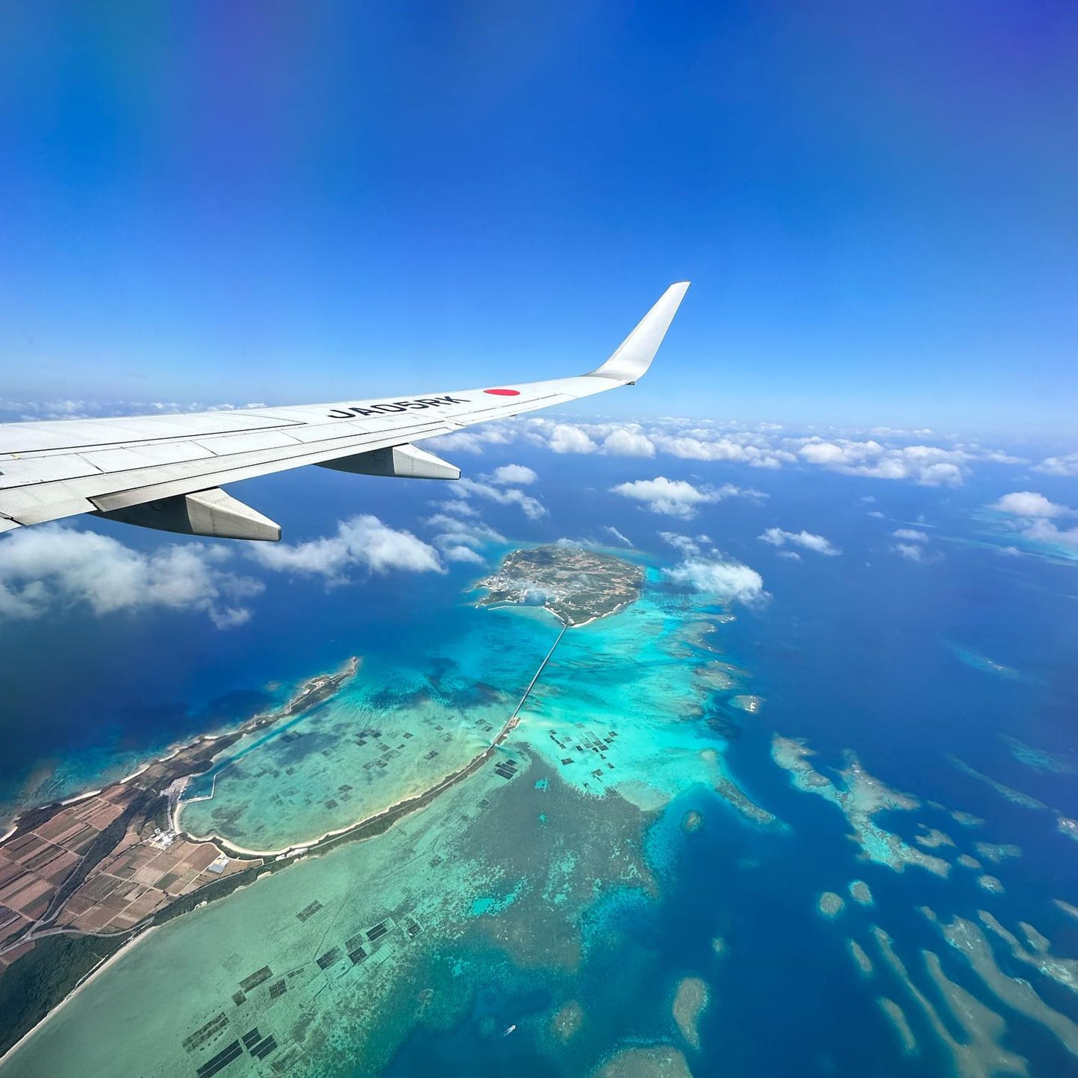 【宮古島の光と闇】

7年ぶりの宮古島
大好きなJTAから見た景色。

宮古島の海はとにかく美しい。
慶良間とも石垣ともちがう、独特の《宮古ブルー》

あまりに青すぎて、思わずため息が出る。そんな島。

島民は約5.5万人。観光客の最多は2018年に114万人。

オーバーツーリズムが指摘される中、島の暮らしと環境のために作られた《エコアイランドパスポート》

観光客と共に島を守ろうという目的で、島や自然への配慮などが書かれている。

各ビーチに海のマナー看板があり、島としての意識が高い！
（沖縄本島にもぜひ建てたい…😭）

一方では、2018年にはリゾート開発ラッシュ
今になって、再び高級ホテルのオープンが続いてる。

家賃も爆上がりで、1 Rアパートは築8年で8万円。
もちろん賃金は変わらない。
（本島でぼくの部屋は築2年で4万円）

そして、お隣の下地島では
自衛隊駐屯地建設
空港の軍事利用の議論
島を取り巻く環境は変わっていた。

伊良部大橋には、歩道も街灯もない。
実は、予算都合ではなく《有事を想定した軍事車輌のため》だと話す地元の方もいる。
（真偽は諸説あるはず）

島に残される伝統や人の繋がり、美しい自然を千年先へ引き継ごうと前に進むエコアイランド宮古島。

その裏で、なんとも言えない〈暗いもの〉を感じずにいられなかった。

#宮古島観光 
#ジャパントランスオーシャン航空 
#エコアイランド 
#離島旅 
#伊良部大橋 
#宮古島の海 
#リゾート開発 
#サスティナブル 
#エシカル 
#宮古島観光協会 
#miyakojimatrip-1